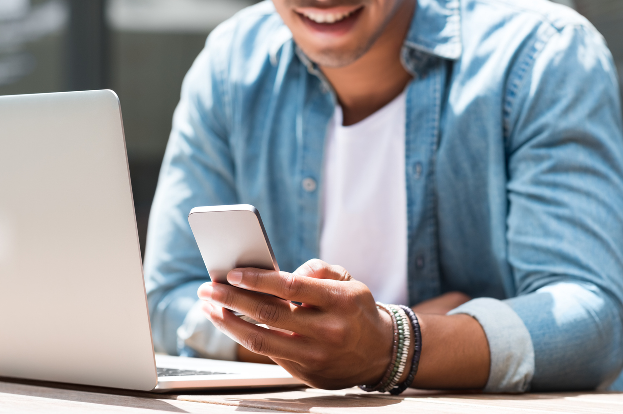 Person checking their phone for email updates, representing the importance of email marketing for client engagement in salons