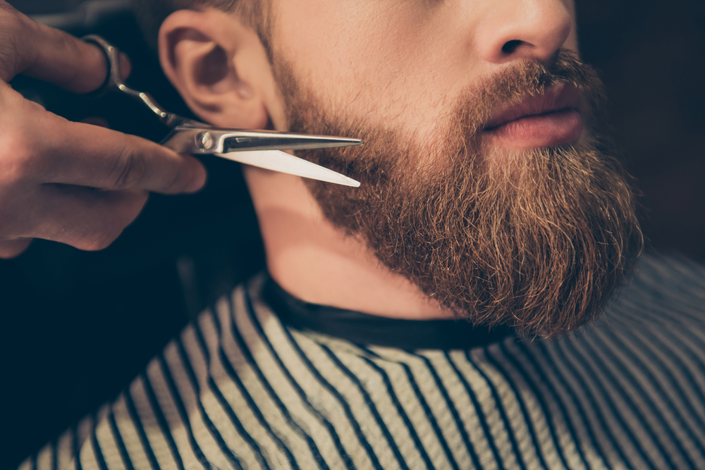 Close-up of a barber trimming a client's beard.