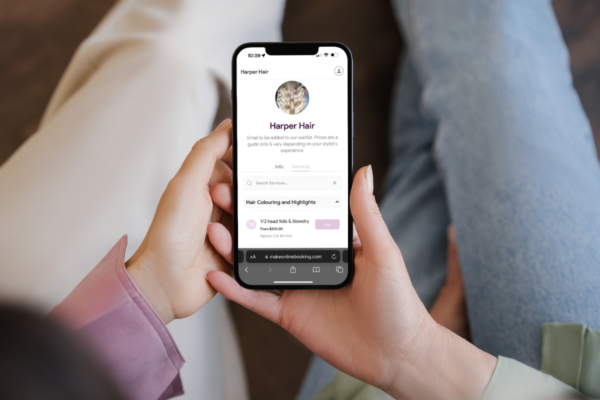A person using a mobile phone to book salon services online, highlighting the convenience of digital booking for salon clients.