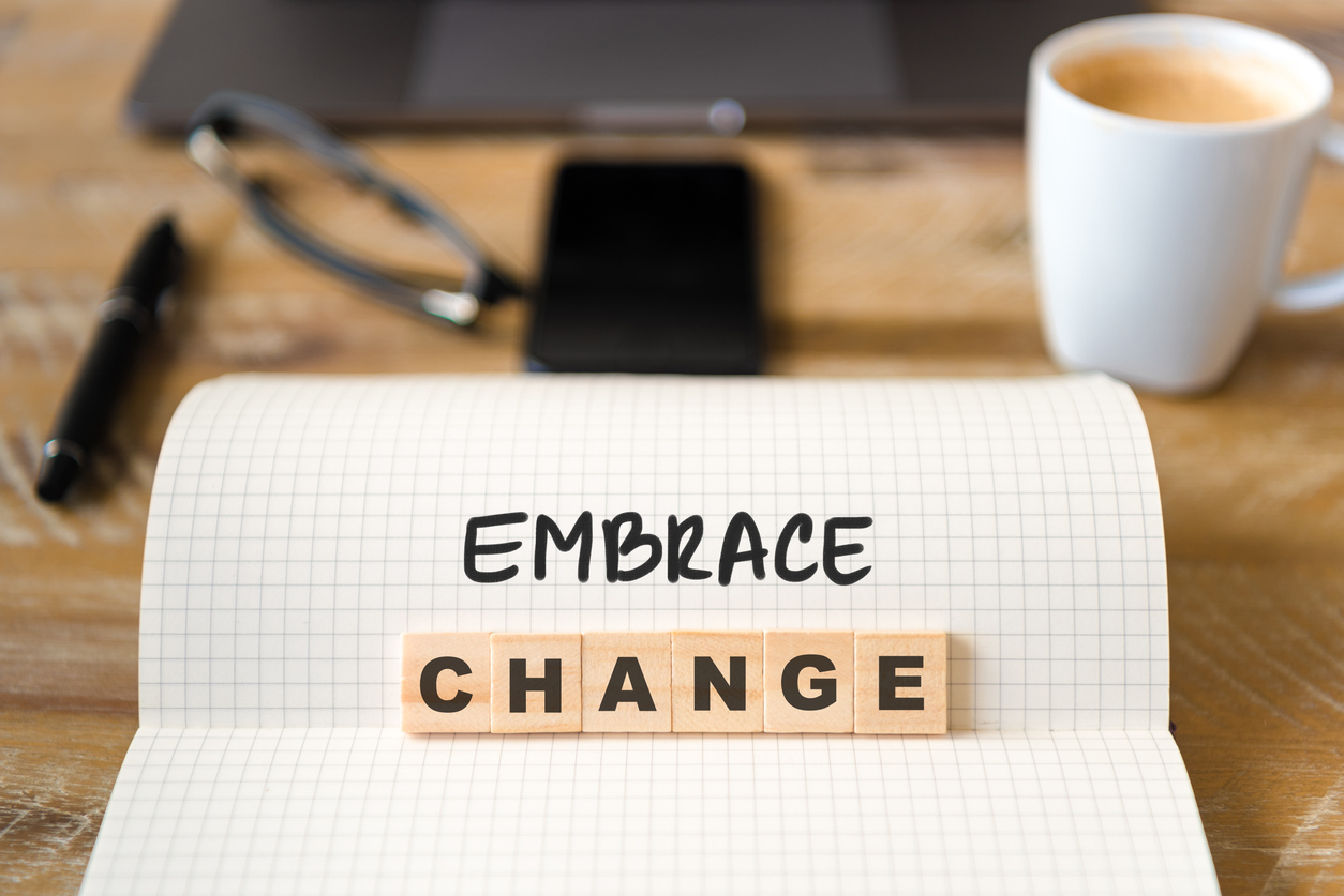 Notebook with the phrase 'Embrace Change', encouraging salon owners to adopt new marketing strategies for growth.